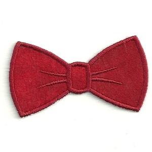 May include: A red fabric bow tie patch. This patch is perfect for adding a touch of whimsy to clothing, bags, or other accessories.