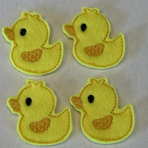 May include: Four yellow felt rubber ducky appliques with black eyes and yellow beaks. The ducks are outlined in yellow thread.