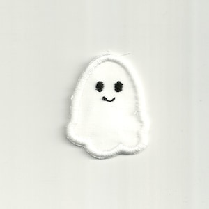 May include: White felt ghost with black embroidered eyes and a smiling mouth.