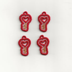 Puede incluir: Cuatro abalorios de llave bordados de color rojo con un diseño de corazón y ojo de cerradura dorado. Los abalorios son perfectos para añadir un toque de fantasía a tus manualidades.