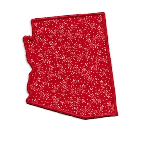 May include: Red fabric patch in the shape of the state of Arizona with a white floral pattern.