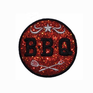 May include: Red round iron-on patch with black glitter and the text "BBQ" in a vintage font. The patch also features a white star and two crossed grilling tools.