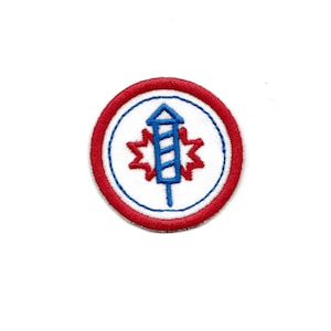 May include: A red, white, and blue embroidered patch with a firework design. The firework is blue and white with a red starburst around it.