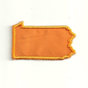 Könnte beinhalten: Orangefarbener Filz-Umriss des Bundesstaates Pennsylvania mit einem gelben, gestickten Rand.
