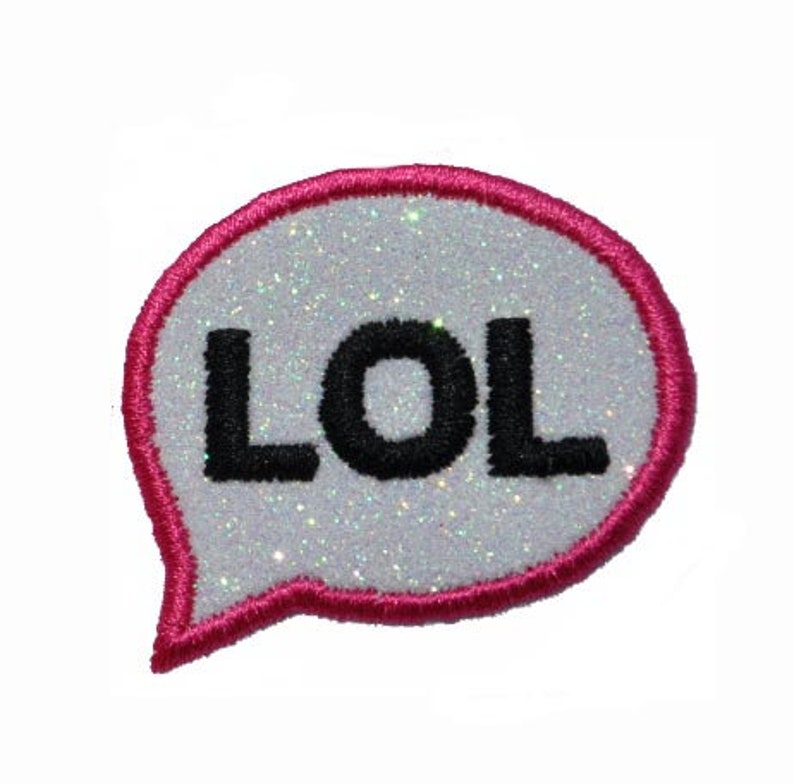 May include: A pink and white iron-on patch with the word "LOL" in black letters. The patch is shaped like a speech bubble.