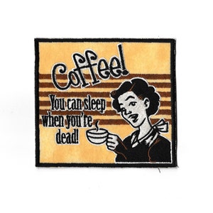 Op de afbeelding: Een bruin en geel geborduurd patch met een cartoonvrouw die een kopje koffie vasthoudt. De tekst op het patch luidt "Coffee! You can sleep when you're dead!"