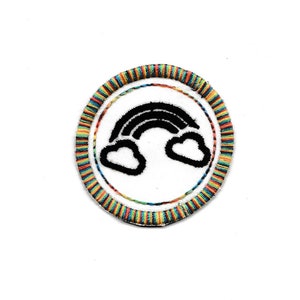 以下が含まれることがあります： 白い背景に黒い虹と白い雲が描かれた、円形の刺繍パッチ。 パッチの縁は虹色のストライプの糸で縁取られています。 シンプルでカラフルなデザインで、衣類やアクセサリーに適しています。