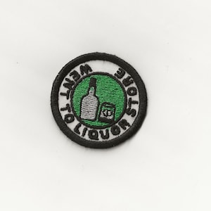 May include: A black and white embroidered patch with a green circle in the center. The circle contains a white bottle and a glass of liquor. The text around the circle reads "Went to Liquor Store".