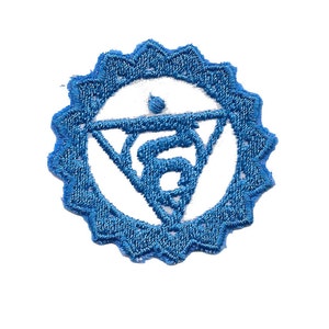 May include: Blue embroidered patch with a white symbol of a triangle with a circle inside, representing the fifth chakra, the throat chakra.