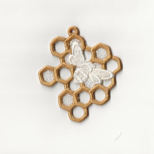 May include: A gold embroidered honeycomb design with a white embroidered bee in the center.
