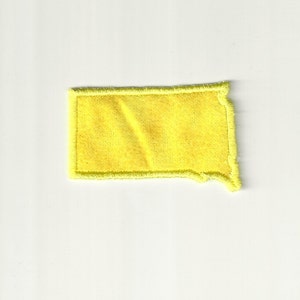 May include: A yellow felt state of Montana patch with a stitched border.