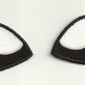 Pode incluir: Dois patches bordados em forma de olhos estilizados. Cada patch apresenta um contorno preto com uma forma interior branca e curva, que se assemelha ao brilho de um olho. Os patches são projetados para serem costurados no tecido.