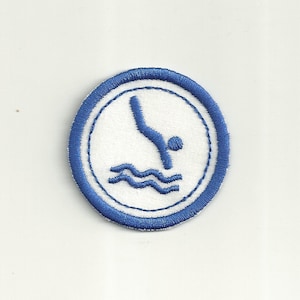 May include: Blue and white embroidered patch with a diver silhouette and waves. The patch is circular and has a white background with a blue border.