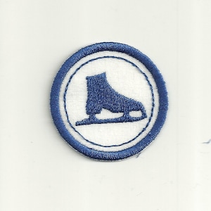 May include: A blue embroidered ice skate patch with a white background and a blue circle border.