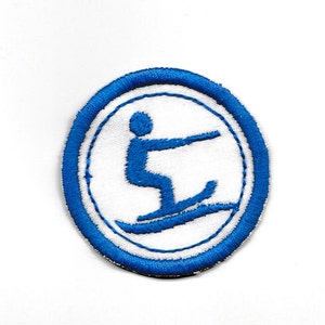 May include: A blue and white embroidered patch with a white silhouette of a person water skiing.