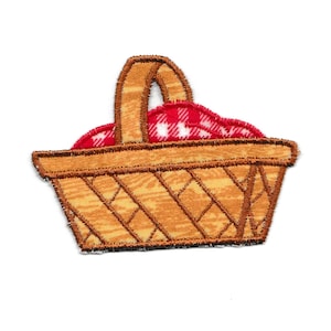 May include: A brown wicker picnic basket with a red and white checkered blanket inside.