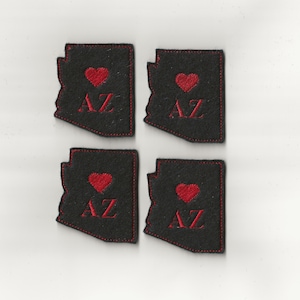 Könnte beinhalten: Vier schwarze Filzpatches in Form des Bundesstaates Arizona mit einem roten Herzen und den in Rot gestickten Buchstaben "AZ".