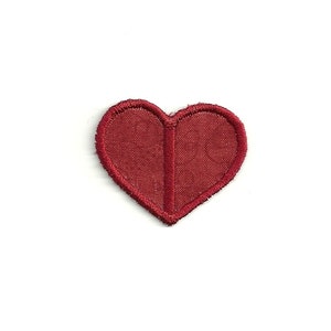 May include: A small red felt heart with a stitched outline.