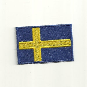 Op de afbeelding: Een geborduurde patch met de Zweedse vlag, met een geel kruis op een blauwe achtergrond.