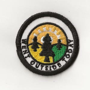 Puede incluir: Un parche bordado blanco, negro, amarillo y verde con un sol, árboles y el texto "Went Outside Today".