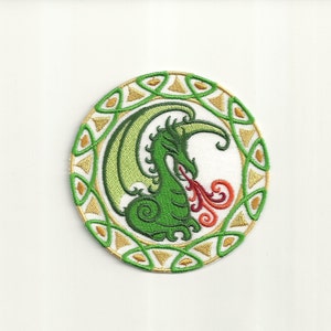 May include: Green embroidered dragon with red and orange flames, inside a circular frame with a Celtic knot design.