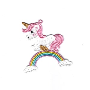 May include: A white unicorn with a pink mane and tail stands on a rainbow with white clouds. The unicorn has a gold horn and hooves.