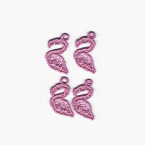 Peut inclure: Quatre breloques en dentelle de flamants roses. Les breloques sont délicates et complexes, avec un design détaillé.