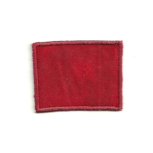 May include: A red fabric patch with a stitched border.