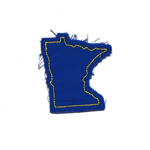 May include: A blue fabric patch in the shape of the state of Minnesota with a yellow outline.