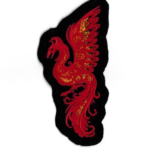 Könnte beinhalten: Gestickter Phönix-Aufnäher in Rot und Gold auf schwarzem Hintergrund.