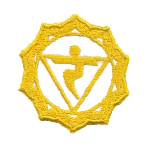 May include: Yellow embroidered patch with a white symbol of a stylized human figure inside a circle. The symbol is a triangle with a curved line inside.