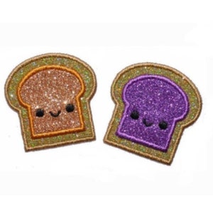 Peut inclure: Deux patchs brodés en forme de tranches de pain. L'un est brun avec un visage heureux et l'autre est violet avec un visage heureux.