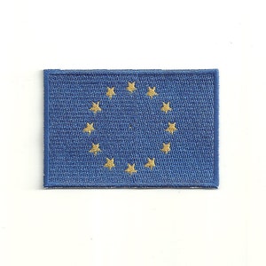 Può includere: Un cerotto di stoffa blu con un cerchio di 12 stelle dorate, che rappresenta la bandiera dell'Unione Europea.