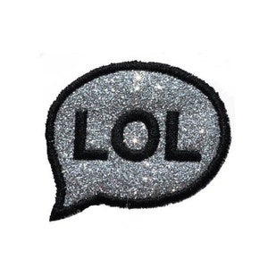 May include: A silver glitter speech bubble with the word "LOL" in black lettering.