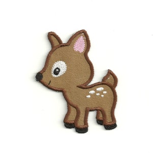May include: A brown embroidered patch of a cartoon fawn with white spots and pink ears. The fawn is standing on all four legs and has a white eye with a black pupil.