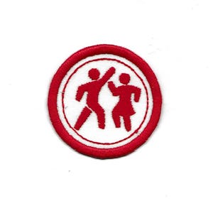 May include: Red embroidered patch with a white circle in the center. The circle features two red stick figures dancing.