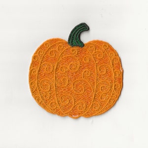 Könnte beinhalten: Orangefarbener Kürbis mit grünem Stiel und einem detaillierten, gestickten Design. Der Kürbis ist ein dekorativer Patch.