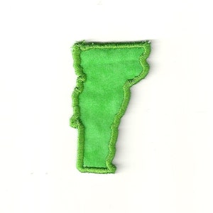May include: Green felt outline of the state of Vermont with a zig-zag edge.