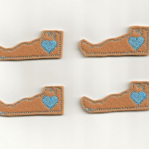 Puede incluir: Cuatro parches de fieltro marrón con forma del estado de Virginia con un corazón azul en el centro de cada parche.