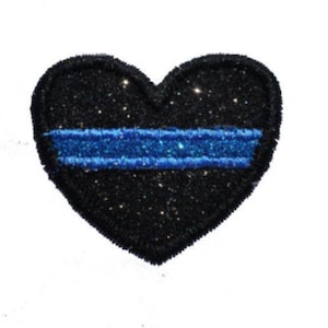 Pode incluir: Um coração preto com glitter com uma fina linha azul no centro.