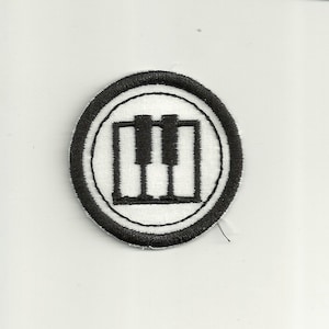 May include: A white embroidered patch with a black outline and a black piano keyboard design inside.