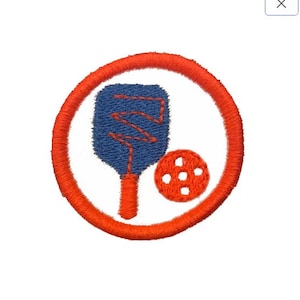 Könnte beinhalten: Ein roter Kreis mit weißem Hintergrund und einem blau-orangenen Schläger und einem roten Ball mit Löchern.