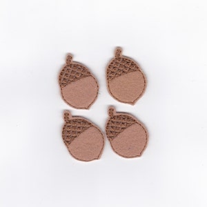 May include: Four brown felt acorn shapes with embroidered details.