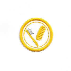May include: A yellow embroidered patch with a white toothbrush and toothpaste and a comb inside a circle.