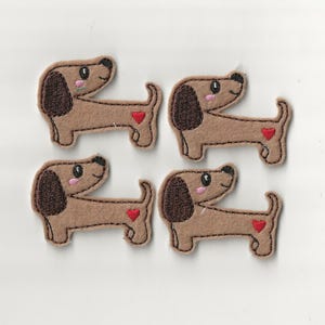 May include: Four brown dachshund dog patches with dark brown ears and a red heart on the side. The dogs have black eyes and pink cheeks. These patches are perfect for adding to clothing or accessories.