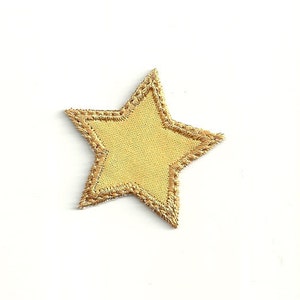 May include: A gold star-shaped patch with a yellow fabric center. The star is outlined with a gold thread.