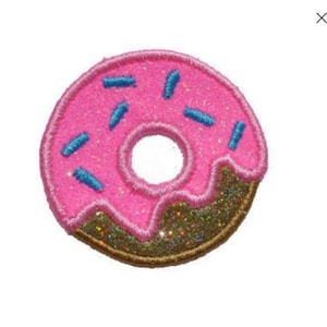 Könnte beinhalten: Ein rosafarbener Donut mit blauen Streuseln und braunem Zuckerguss. Der Donut ist aus Filz und hat eine glitzernde Textur.