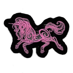 May include: Pink embroidered unicorn patch with intricate details on a black background.