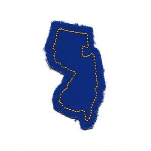 May include: A blue fabric patch in the shape of the state of New Jersey with a gold outline.