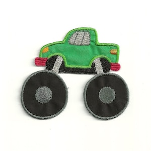 May include: Green monster truck applique with red, orange, and gray details. The truck has large black tires with gray centers.